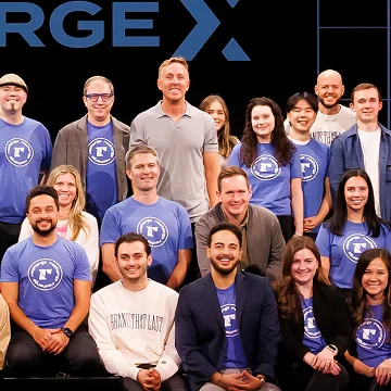 A large group photo of team members wearing matching shirts at an event.