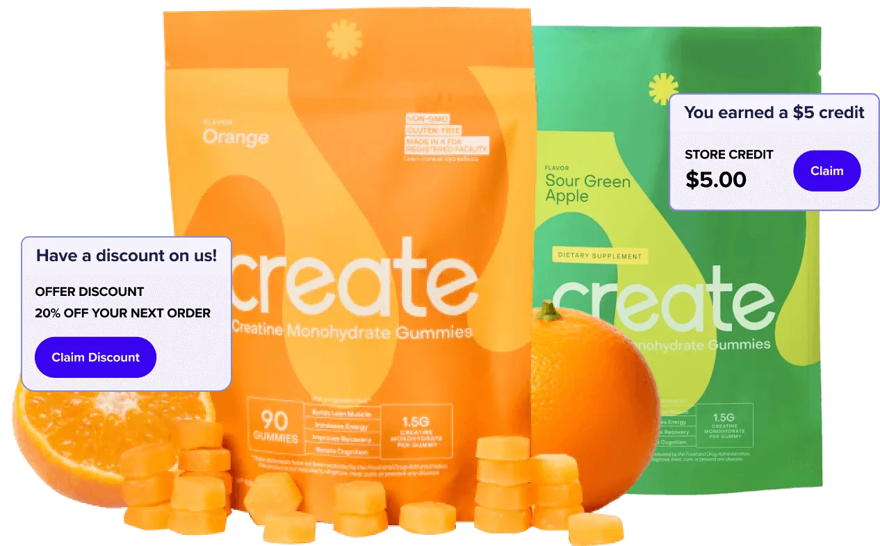 Bags of Create creatine gummies surrounded by loose gummies and a sliced orange