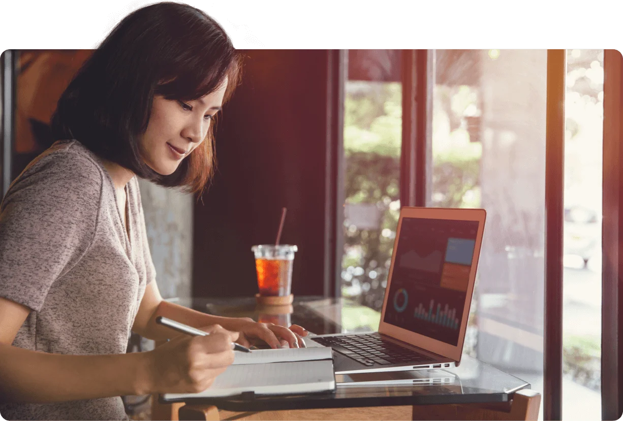 Woman working on a laptop showing an analytics dashboard