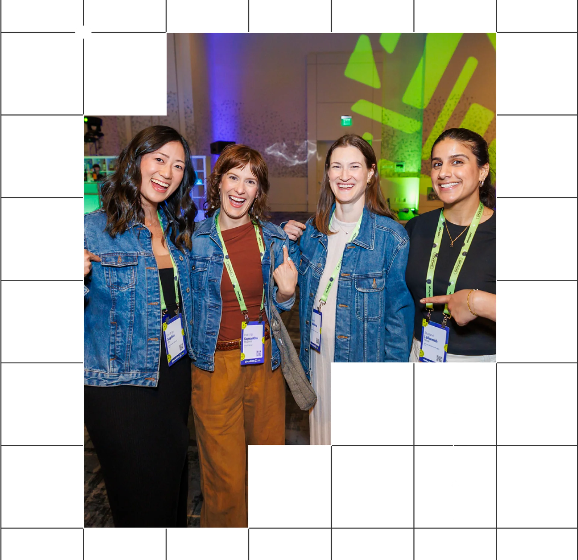 Four individuals wearing denim jackets and lanyards smiling together at an event.