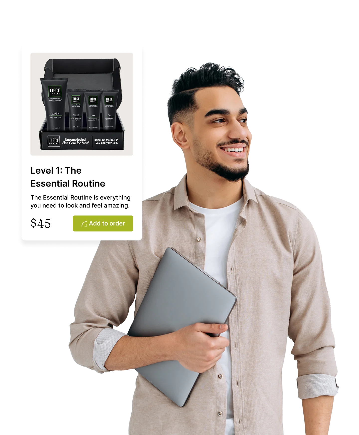 A person holding a laptop and smiling while looking at a skincare product set.