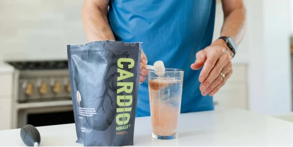 A person adding Cardio Miracle powder to a glass of water.