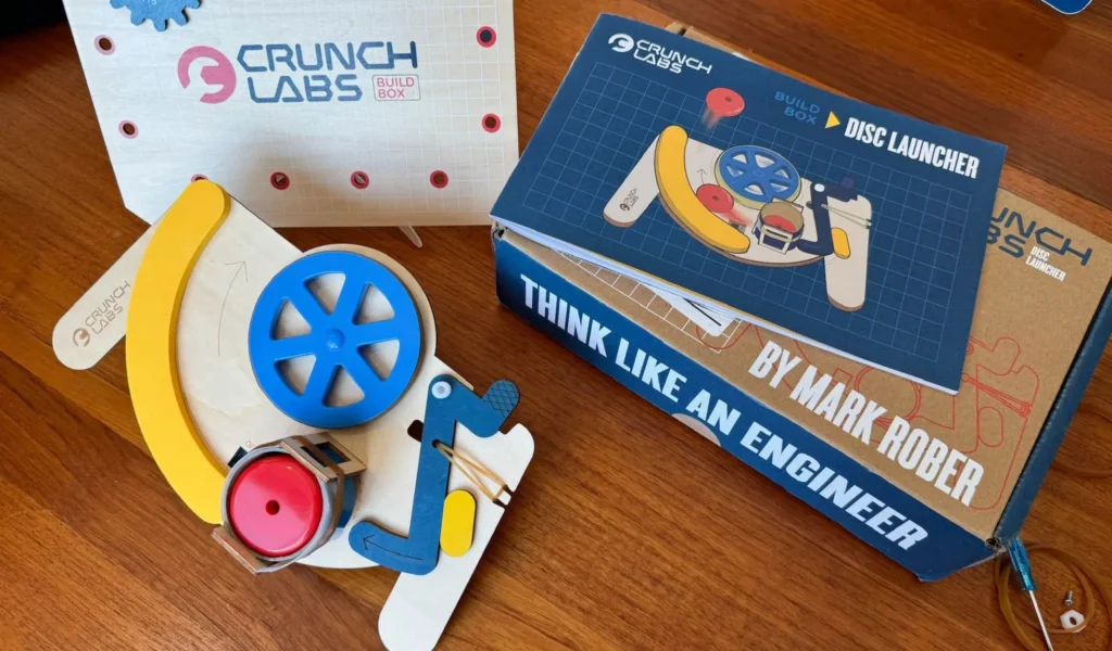 CrunchLabs Disc Launcher Kit components displayed on a wooden table.