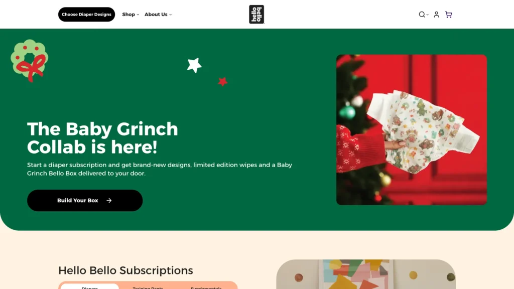 A hand holding a diaper with Christmas designs alongside a decorated tree.