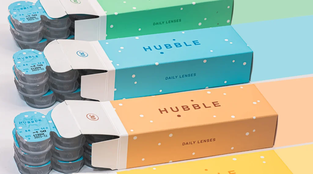 Three Hubble contact lens boxes in different colors arranged in rows.