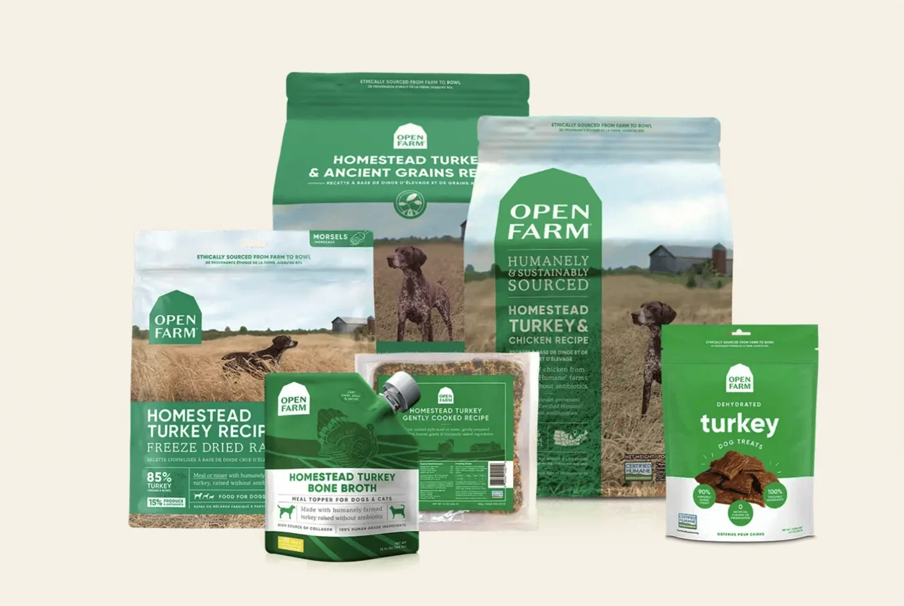 Various dog food products from Open Farm on a neutral background.