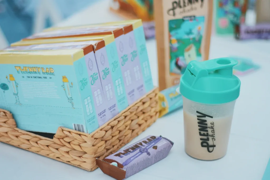 Packaging of Plenny Shake and Twenny Bar displayed on a table.