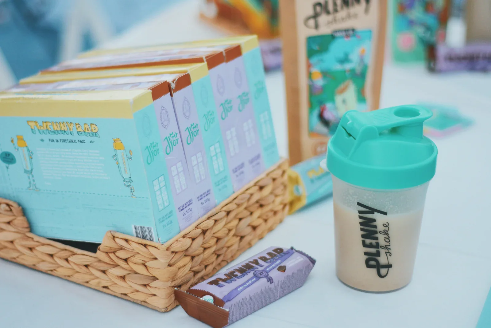 Packaging of Plenny Shake and Twenny Bar displayed on a table.