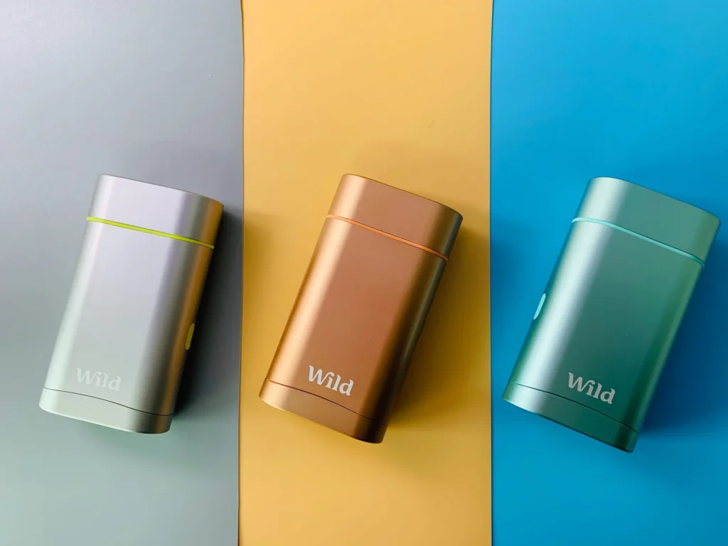 Three Wild containers in different colors sitting on colorful backgrounds.