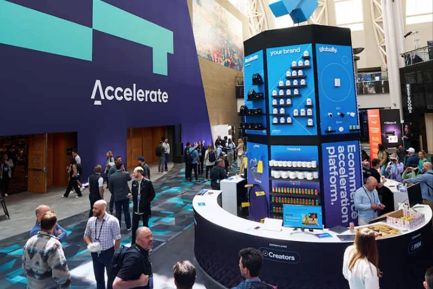 A busy exhibition space with a large purple wall displaying the word Accelerate.