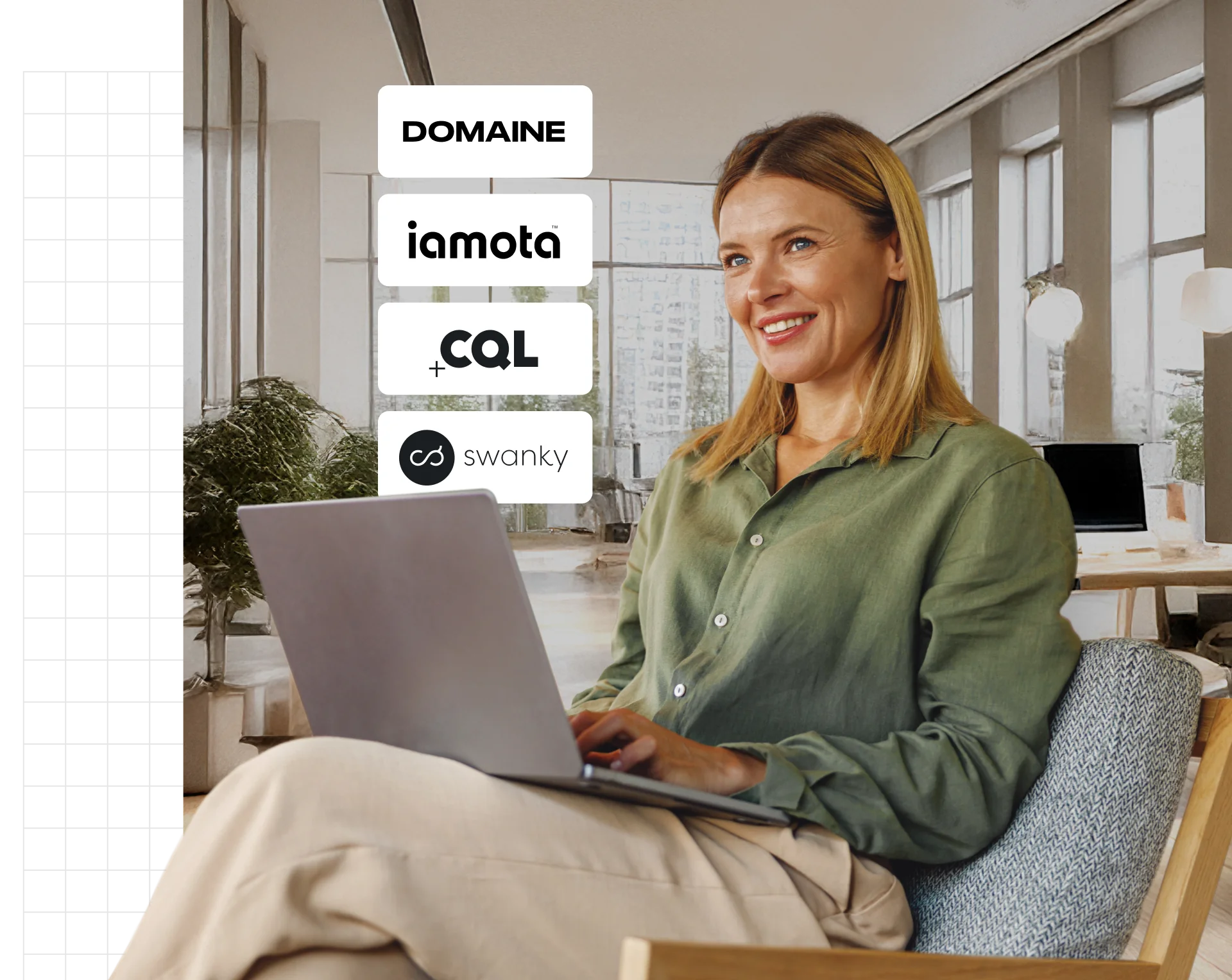 A person smiling while using a laptop in a bright office.