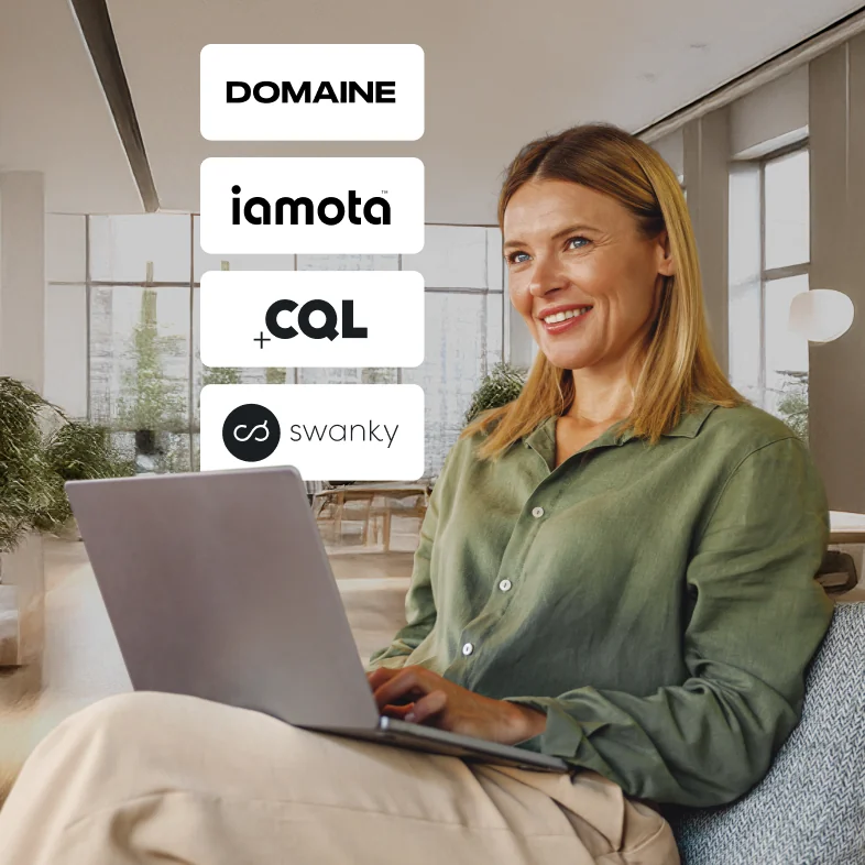 A person with long hair using a laptop in a modern workspace.