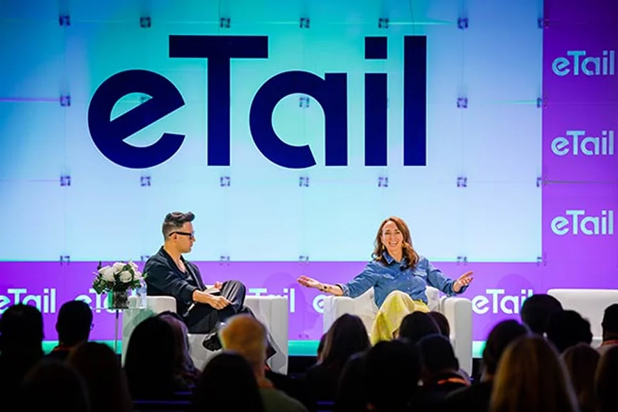 A panel discussion featuring two speakers on stage with an audience in a conference setting.