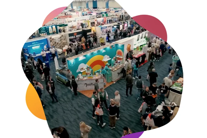 Aerial view of an exhibit hall filled with attendees and various vendor booths.