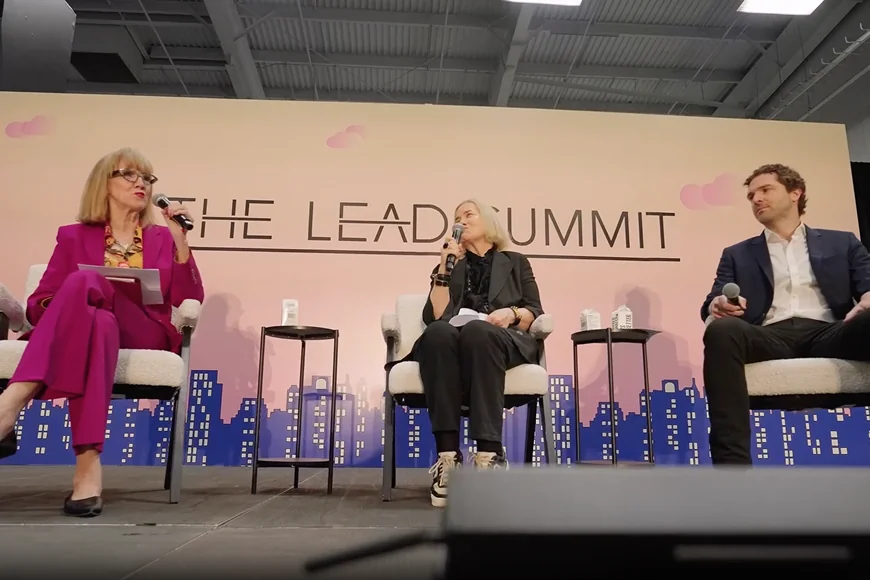 A panel discussion during The Lead Summit with three speakers on stage.
