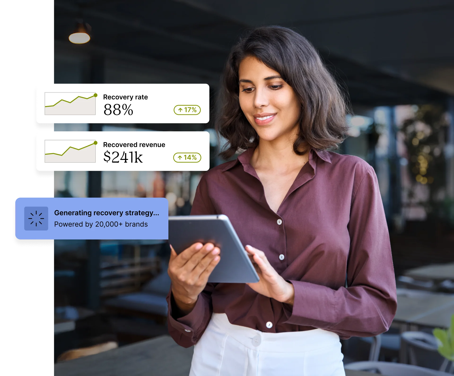 A person using a tablet displaying recovery rate and revenue statistics.