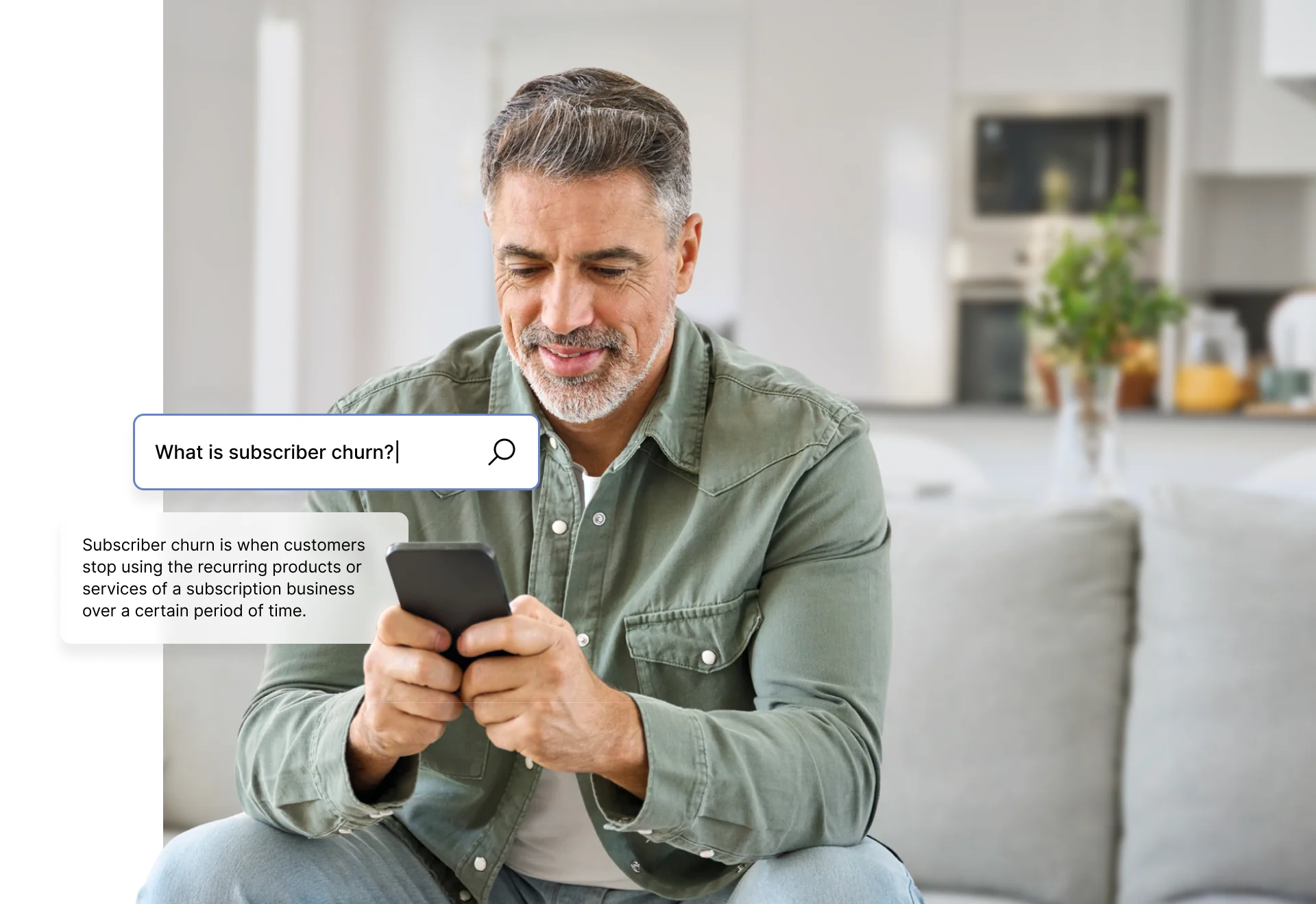 A person sitting on a couch, looking at a smartphone with search text about subscriber churn on the screen.
