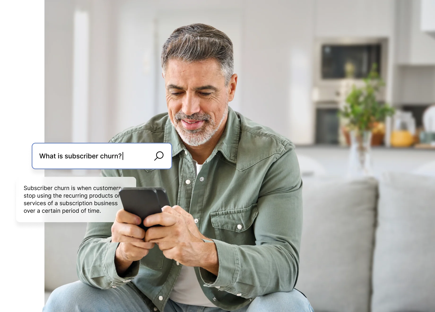 A person sitting on a couch, looking at a smartphone with search text about subscriber churn on the screen.