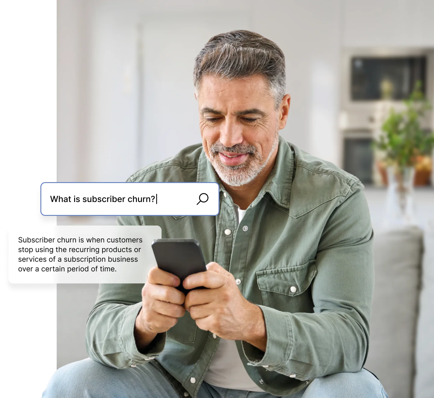 A person sitting on a couch, looking at a smartphone with search text about subscriber churn on the screen.