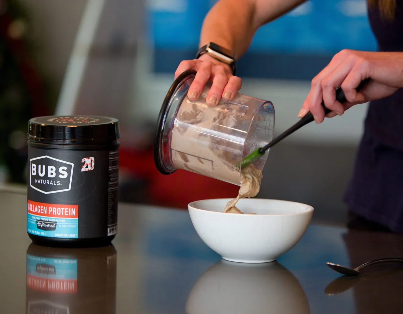 A person pouring Bubs Naturals Collagen Protein from a blender into a bowl.